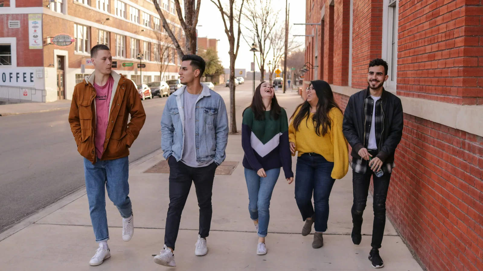A diverse group of international students walking and laughing together along a city street